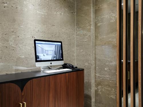 a computer monitor sitting on top of a desk at The Tango Hotel Taipei Linsen in Taipei