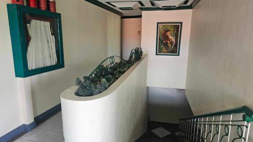 a hallway with a staircase with a painting on the wall at Green Mellow Court in Dipolog