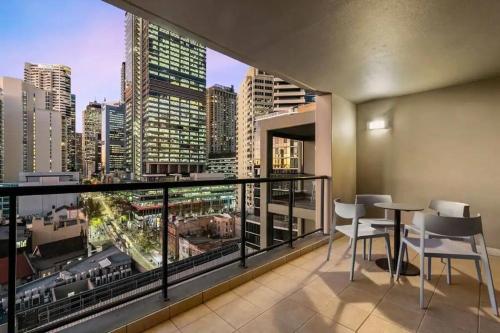 a balcony with chairs and a view of a city at KozyGuru | Haymarket | High Level 2B APT 16 in Sydney