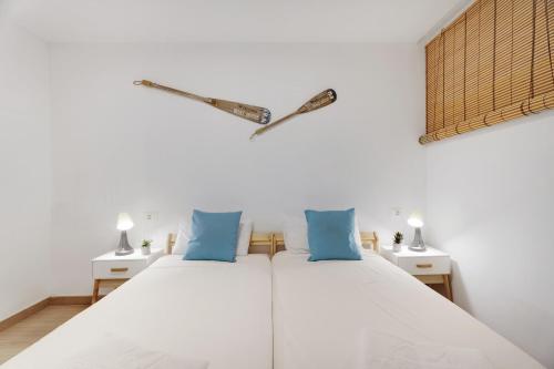a bedroom with a white bed with blue pillows at Apartamento Playa Honda in Playa de las Americas
