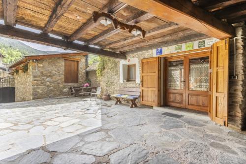 a patio with a wooden door and a bench at El Raco De Cal Maró in Vall de Castellbò