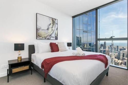 a bedroom with a bed and a large window at Sleek Lvl 75 Apt w Skyline Views in Aurora Complex in Melbourne