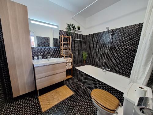 une salle de bain avec une baignoire, des toilettes et un lavabo dans l'établissement La cabane de Charlie, à Le Broc