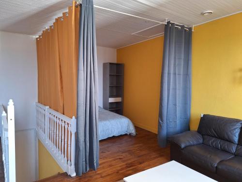 un salon avec un canapé et un lit dans l'établissement La cabane de Charlie, à Le Broc