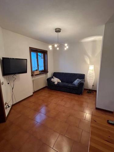 a living room with a couch and a flat screen tv at Sole e Neve -Sun & Snow in Forno di Zoldo
