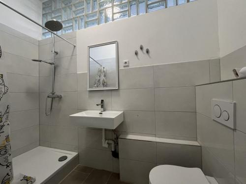 a white bathroom with a sink and a toilet at Cozy Apartment in Leverkusen in Leverkusen
