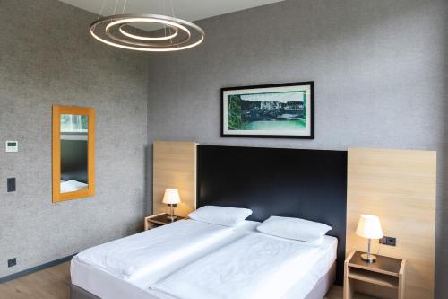 a bedroom with a large bed with a large white bedspread at Hotel Franziskushöhe Lohr in Lohr
