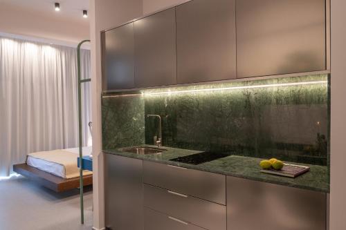 a kitchen with a counter with a sink and a bed at Infinity Blue next to the sea in Kalamata