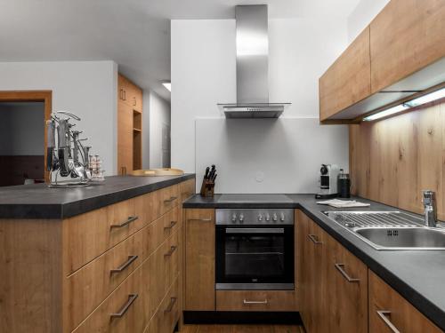 a kitchen with wooden cabinets and a stove top oven at Attractive apartment in Wald am Arlberg in Wald am Arlberg