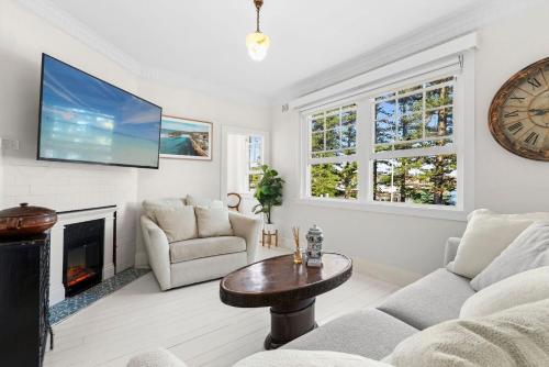 a living room with a fireplace and a tv at Manly Harbour in Sydney