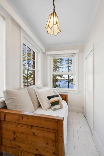 a bed in a room with two windows at Manly Harbour in Sydney