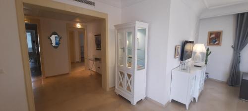 a living room with a white cabinet and a television at Le Bleu Céleste in Hammamet