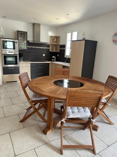 une cuisine avec une table en bois et deux chaises dans l'établissement Le Petit Moussaillon, à La Flotte