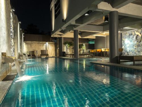 una piscina en un hotel por la noche en Thapae Loft, en Chiang Mai