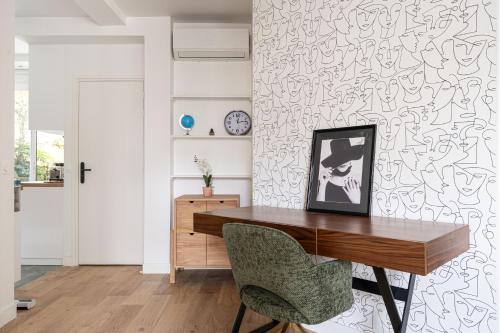 un bureau avec un bureau en bois et une chaise dans l'établissement Grand appartement climatisé 2BR avec terrasse, à Paris