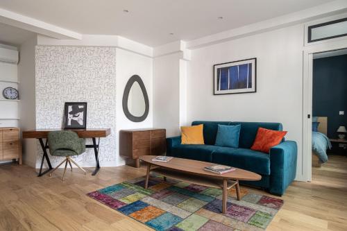 un salon avec un canapé bleu et une table dans l'établissement Grand appartement climatisé 2BR avec terrasse, à Paris