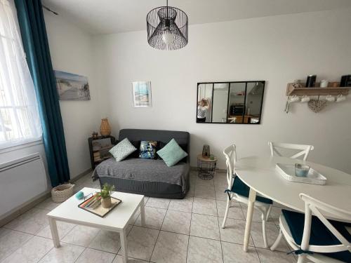 un salon avec un lit et une table dans l'établissement Appartement et cour St Jean de Monts +parking, à Saint-Jean-de-Monts