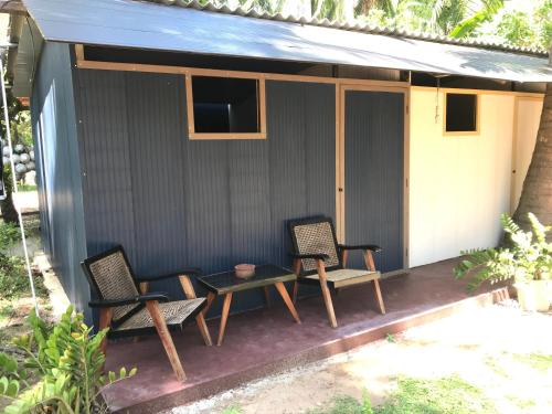 a patio with chairs and a table and a television at Salt Bay Kite Resort in Kalpitiya