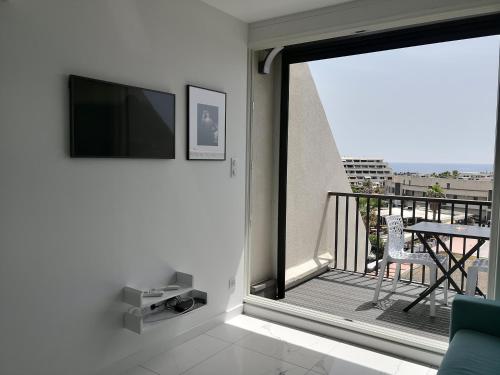 Il comprend un salon doté d'un balcon et d'une télévision à écran plat. dans l'établissement Cosy Studio Héliopolis H Village Nat Vue mer, au Cap d'Agde