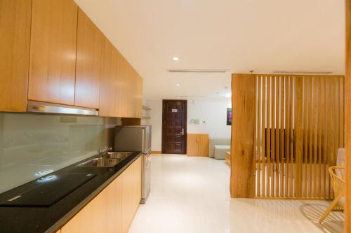 a kitchen with wooden cabinets and a counter top at Hai Phong Tower - Apartment & Hotel in Hai Phong