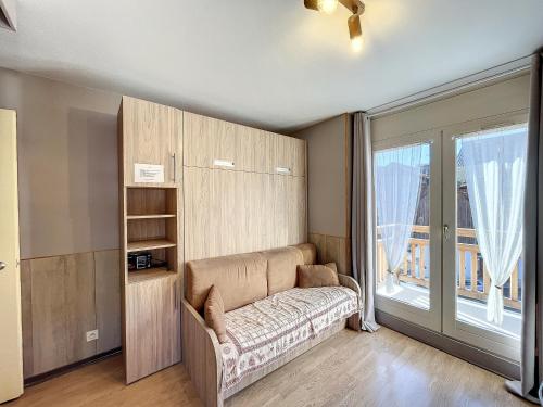 un salon avec un canapé et une grande fenêtre dans l'établissement Ceylan - appartement - 5 pers - centre, aux Gets