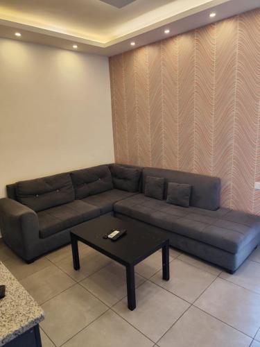 a living room with a couch and a coffee table at Gentle Breeze Studio 3 in Amman