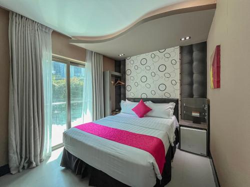 a bedroom with a large bed and a large window at Eloisa Royal Suites in Mactan