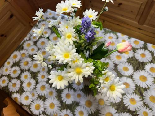 a vase filled with white flowers on a table at Casa Margherita - Valbruna in Valbruna