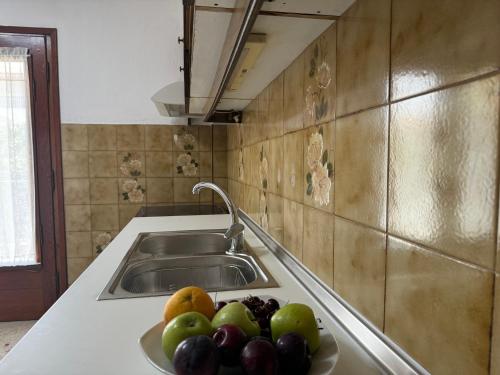 a plate of fruit on a counter next to a sink at Villa Galini Ierissos in Ierissos