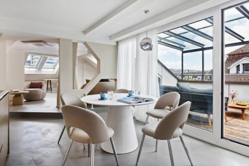 a living room with a table and chairs and a large window at VISIONAPARTMENTS Brandschenkestrasse - contactless check-in in Zürich