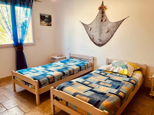 une chambre avec deux lits et un poisson accroché au mur dans l'établissement Spacieuse Maison de Vacance Villa Les Lavandins, à Puisserguier