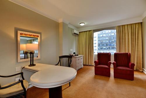 a room with a table and two chairs and a window at The Capetonian - Halal in Cape Town