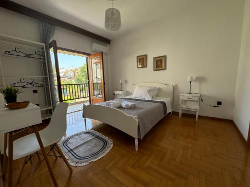 a bedroom with a bed and a desk and a window at Villa Galini Ierissos in Ierissos