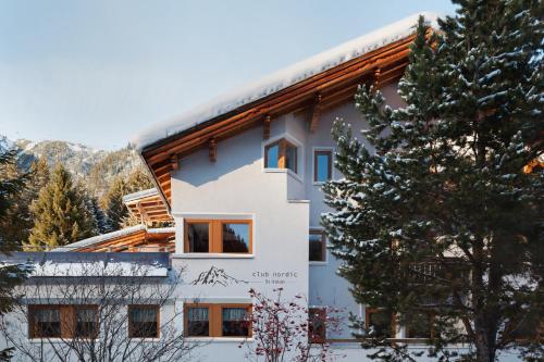 a house in the snow with a tree at Club Nordic in Sankt Anton am Arlberg