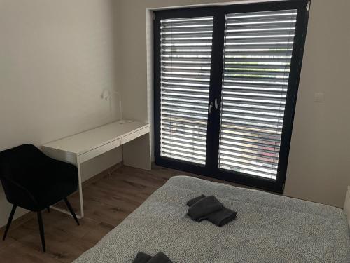 a bedroom with a desk and a bed and a chair at City Apartment - Michalovce in Michalovce