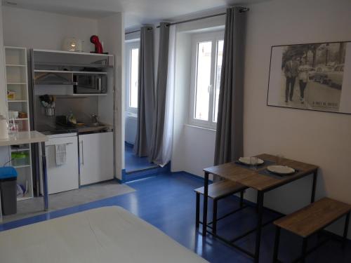un salon avec une table et une cuisine dans l'établissement Studio 27m2 centre-ville, à Bourges