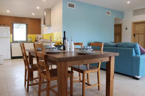 Il comprend une cuisine et une salle à manger avec une table et des chaises en bois. dans l'établissement The Grape and Olive at Willunga, à Willunga