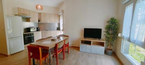 une cuisine avec une table et des chaises ainsi qu'une télévision dans l'établissement Air M&N'S # Paris - Aéroport CDG - Parc Astérix #, à Louvres