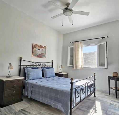 a bedroom with a bed and a ceiling fan at Tinoshomelidays Residences in Venardatos