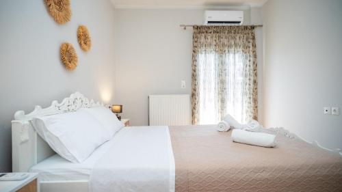 Un dormitorio blanco con una cama blanca y una ventana. en I & G Family Apartment, en Kalambaka