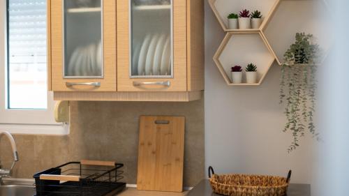 Una cocina con gabinetes de madera y plantas en macetas en la pared. en I & G Family Apartment, en Kalambaka