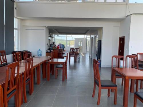 Un comedor con mesas y sillas de madera. en SinE Hotel VT by BAY LUXURY, en Vung Tau