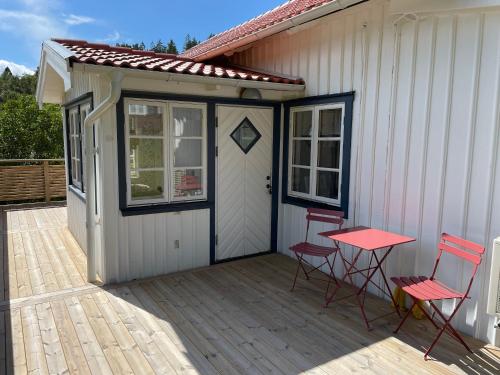 a patio with two chairs and a door and a table at Råssbyn Hassleliden 324 in Ljungskile
