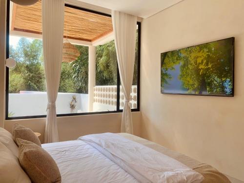 a bedroom with a bed and a large window at Villa Molly By The Villas 100 in Cilama