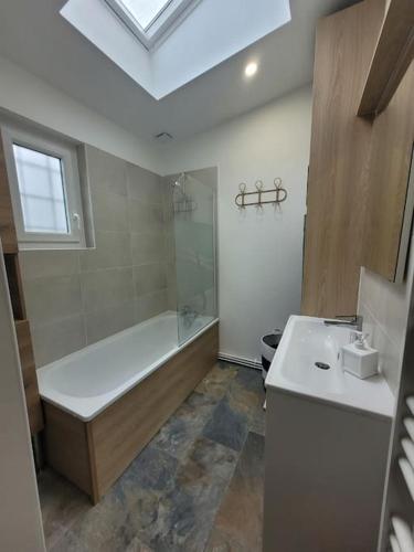 une salle de bain avec une baignoire et un lavabo dans l'établissement La petite maison, à Le Trait