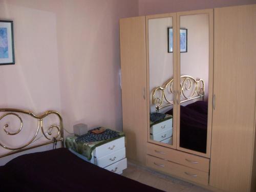 a bedroom with a dresser and a large mirror at Alexa Apartment in Corfu