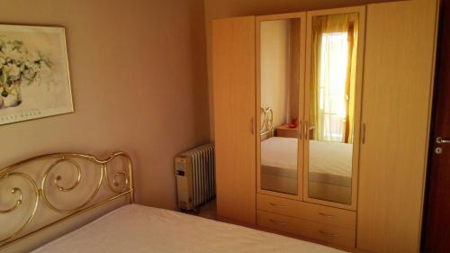 a bedroom with a bed and a closet with a mirror at Alexa Apartment in Corfu