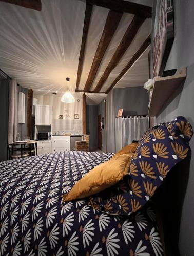 a bedroom with a bed with a blue and white blanket at Studio cosy, cité gastronomique in Dijon