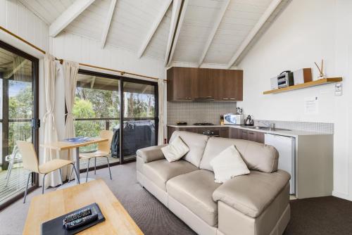 a living room with a couch and a table at Beacon Point Ocean View Villas in Apollo Bay