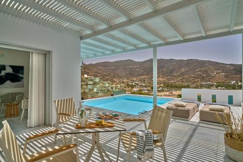 a patio with a pool and a table and chairs at Ios Palace Hotel & Spa in Mylopotas